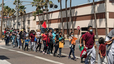 Migrants dropped off in McAllen, Texas, are shown earlier this year walking to a temporary shelter after being tested for Covid-19.