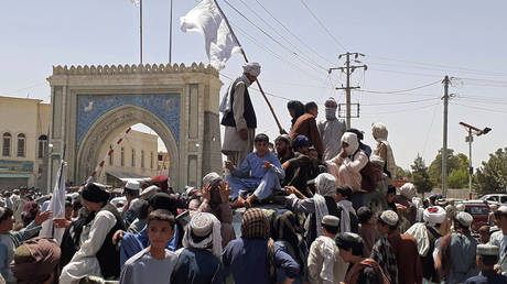 Taliban fighters stand on a vehicle along the roadside in Kandahar on August 13, 2021. © AFP