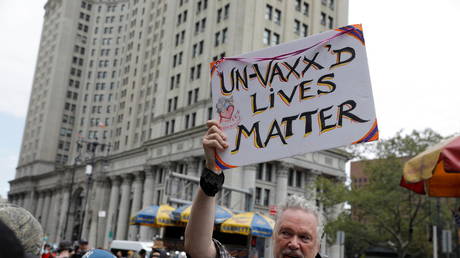 A person holds up a sign during an anti-mandatory coronavirus disease (COVID-19) vaccine protest held outside New York City Hall in Manhattan, New York City, U.S., August 9, 2021. © REUTERS/Andrew Kelly