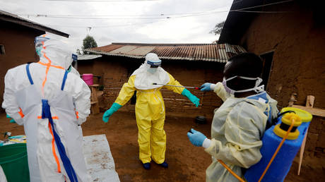 FILE PHOTO: A healthcare worker, who volunteered in the Ebola response, decontaminates his colleague in the eastern Congolese town of Beni in the Democratic Republic of Congo, October 8, 2019 © REUTERS/Zohra Bensemra