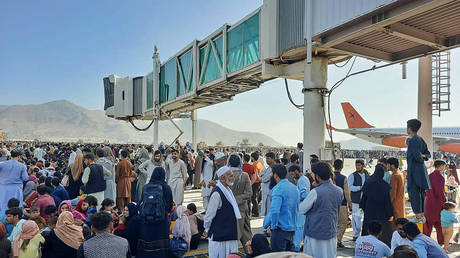 Afghans crowd at the tarmac of the Kabul airport on August 16, 2021, to flee the country as the Taliban were in control of Afghanistan after President Ashraf Ghani fled the country and conceded the insurgents had won the 20-year war. © AFP