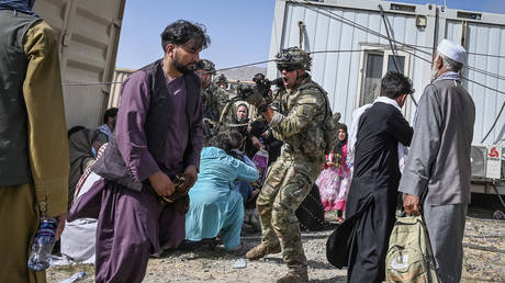 A US soldier point his gun towards an Afghan passenger at the Kabul airport on August 16, 2021 © Wakil KOHSAR / AFP