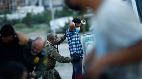 FILE PHOTO: A migrant from Central America is searched by a US Border Patrol agent after crossing into the United States from Mexico, in Sunland Park, New Mexico, July 22, 2021.