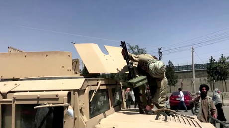 A Taliban fighter reloads his machine gun on top of a US-made Humvee armored car captured in Kabul, Afghanistan August 16, 2021.