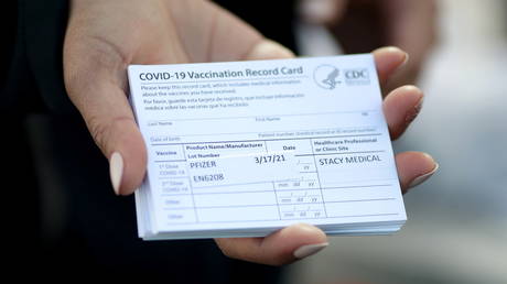 FILE PHOTO: A medical worker holds CDC coronavirus vaccine cards at a mobile vaccination site in Vernon, Los Angeles, California, March 17, 2021.
