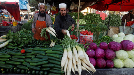 Afghan men sell vegetables at the market as they wait for customers in Kabul, Afghanistan