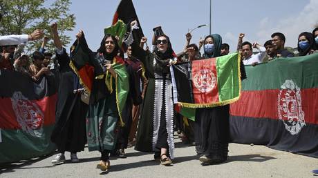 Afghans celebrate the 102th Independence Day of Afghanistan with the national flag in Kabul on August 19, 2021. © AFP / WAKIL KOHSAR