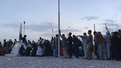 Afghans queue up to board an aircraft to leave Afghanistan at the military airport in Kabul. © AFP  / Shakib Rahmani