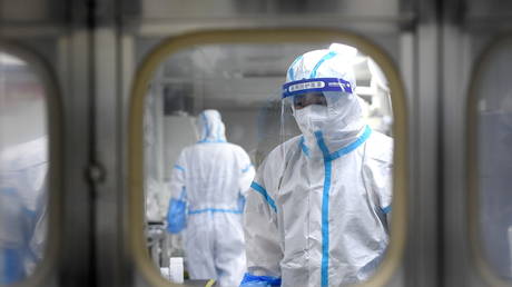 Medical workers in protective suits test nucleic acid samples inside a Huo-Yan (Fire Eye) laboratory of BGI, following new cases of the coronavirus disease (COVID-19) in Wuhan, Hubei province, China (FILE PHOTO) © China Daily via REUTERS