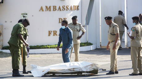 Tanzanian security forces prepare to remove the slain body of an attacker who was wielding an assault rifle, outside the French embassy in the Salenda area of Dar es Salaam, Tanzania August 25, 2021 © REUTERS/Emmanuel Herman