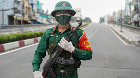 A Vietnamese military personnel stands guard on a deserted road in Ho Chi Minh City on August 23, 2021, after the government imposed a stricter lockdown until September 16 to stop the spread of the COVID-19 coronavirus. © AFP / Pham THO