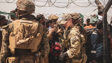 US service members provide assistance during an evacuation at Hamid Karzai International Airport in Kabul, Afghanistan