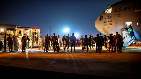 Afghan evacuees leave a US C-17 Globemaster after arriving to Ali Al Salem Air Base, Kuwait, August 24, 2021.