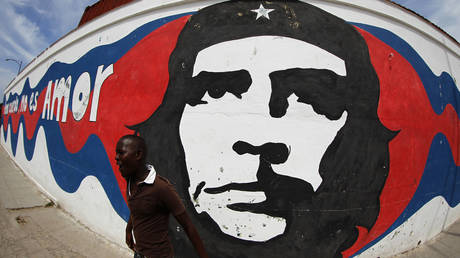 A boy walks past a mural depicting revolutionary Ernesto 'Che' Guevara in Havana, Cuba, April 1, 2012.