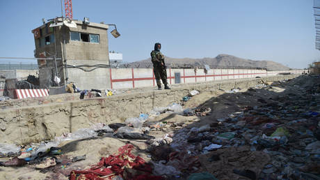 A Taliban fighter stands guard at the site of the attack at Kabul airport © AFP / Wakil Kohsar