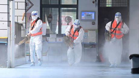 Staff members spraying disinfectant at a primary school ahead of the new school semester in China’s Wuhan. © AFP / STR