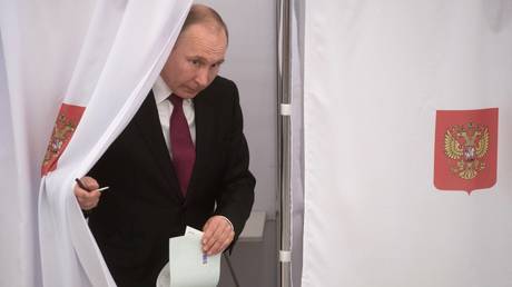FILE PHOTO: Vladimir Putin votes at Russian presidential elections