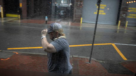 A woman walks in the rain as Hurricane Ida makes landfall in Louisiana, in New Orleans, Louisiana, U.S. August 29, 2021. © REUTERS/Marco Bello