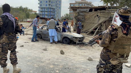 Afghan men take pictures of a vehicle from which rockets were said to be fired in Kabul, Afghanistan on August 30, 2021.