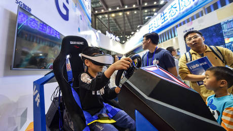 A visitor experiences 5G video games at the 19th China Hi-Tech Fair in Shenzhen, China, November 19, 2017 © Global Look Press / Mao Siqian