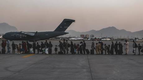 Evacuees wait to board a US Boeing C-17 Globemaster III during an evacuation at Hamid Karzai International Airport, Kabul, Afghanistan, Aug. 23. © U.S. Marine Corps photo by Sgt. Isaiah Campbell