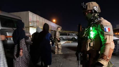 A French soldier watching people walking to board a A400M Atlas military transport aircraft at Kabul airport, Afghanistan on August 24, 2021.