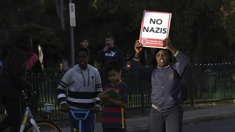 A boy carries a placard during a demonstration in Melbourne, Dec. 4, 2017 © James Ross AAP / Image via AP