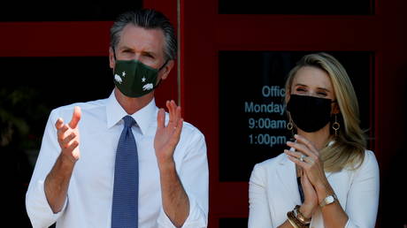 California Governor Gavin Newsom and wife Jennifer Siebel Newsom applaud Kamala Harris in San Leandro, California