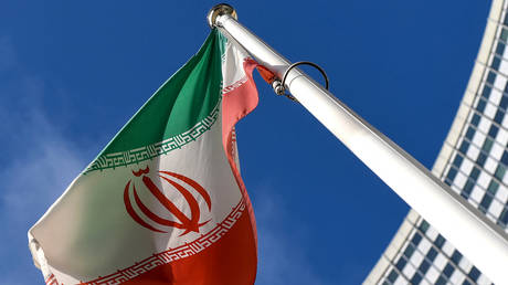 The Iranian national flag is seen outside the International Atomic Energy Agency (IAEA) headquarters during the agency's Board of Governors meeting in Vienna on March 1, 2021. © AFP / Joe Klamar