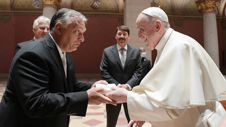 Pope Francis (R), Hungarian Prime Minister Viktor Orban (L) and Hungarian President Janos Ader (back C) exchanging gifts during their meeting in the Romanesque Hall of the Museum of Fine Arts in Budapest. © AFP / VATICAN MEDIA