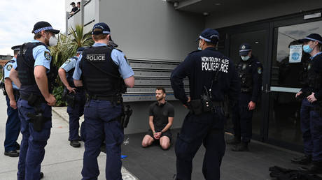 Police detain a man after checking his identification in Sydney on September 18, 2021, following calls for an anti-lockdown protest rally amid the coronavirus pandemic