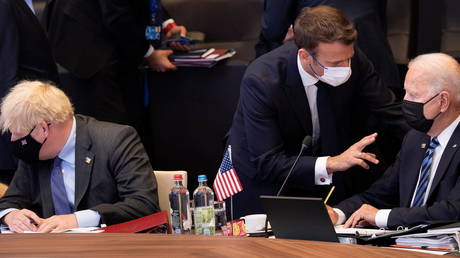 FILE PHOTO: French President Emmanuel Macron talks with US President Joe Biden before a plenary session at a NATO summit in Brussels, Belgium on June 14, 2021