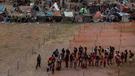 Migrants are prepared for transport as others await to be processed in a makeshift camp along the International Bridge in Del Rio, Texas, September 21, 2021.