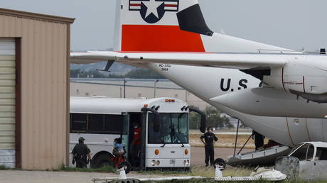 Migrants disembark from a bus before boarding a US Coast Guard plane, as US authorities vow to accelerate deportations, Del Rio, Texas, September 21, 2021.