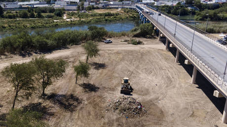 A bulldozer clears the makeshift camp set up by migrants under the Del Rio International Bridge on the US-Mexico border, September 24, 2021.