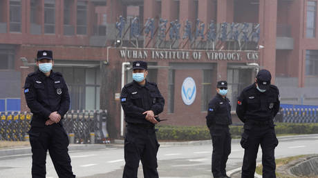 FILE PHOTO: Security personnel gather near the entrance of the Wuhan Institute of Virology during a visit by the World Health Organization team in Wuhan, China, February 3, 2021 © AP / Ng Han Guan