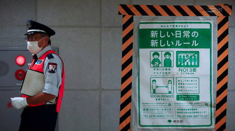 A station employee walks by a coronavrius disease (COVID-19) infection prevention instructions sign at a Tokyo metro station in Tokyo, Japan. July 30, 2021. © REUTERS/Androniki Christodoulou