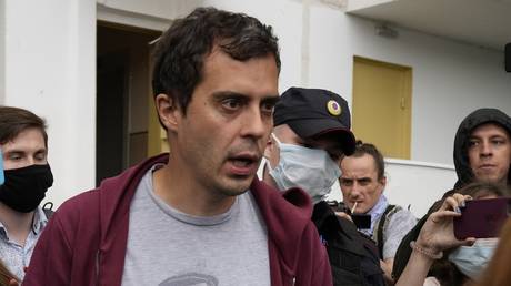 FILE PHOTO. Roman Dobrokhotov, chief editor of The Insider walks surrounded police officers and journalists, in Moscow, Russia. © AP Photo/Alexander Zemlianichenko