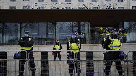 FILE PHOTO. Police officers staff a cordon outside New Scotland Yard, the headquarters of the Metropolitan Police Service, as anti-lockdown protesters march against the ongoing coronavirus restrictions in central London on March 20, 2021. © AFP / Niklas HALLE'N