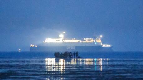 FILE PHOTO: Migrants embark for the UK from the beach in Dunkirk, France, as a ferry sails by in the background, September 22, 2020 © AFP / Sameer al-Doumy