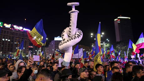 Protesters holding a makeshift syringe with a knot attend a rally against new Covid-19 restrictions in Bucharest, Romania, October 2, 2021.