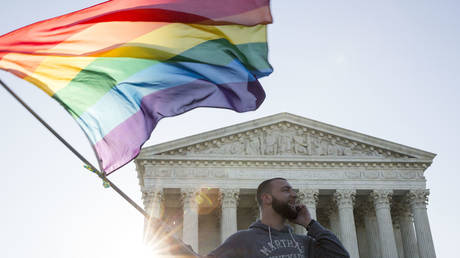 Same-sex marriage supporter waves a rainbow pride flag near the Supreme Court. © Drew Angerer/Getty Images