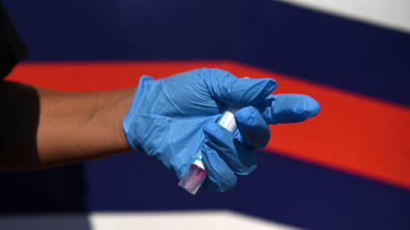 File photo: A healthcare worker holds a completed Covid-19 test sample in Houston, Texas, August 16, 2021.