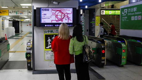 People watch a monitor at Shibuya station, as train services are suspended due to an earthquake, in Tokyo, Japan, October 8, 2021. © REUTERS/Kim Kyung-Hoon