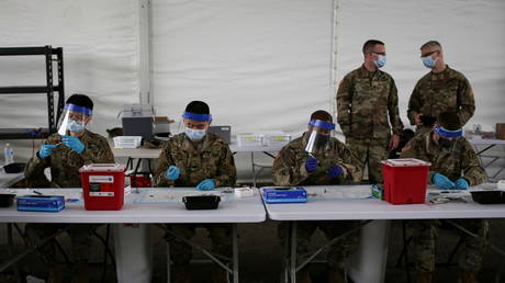 US Army soldiers prepare Pfizer coronavirus disease vaccines at Miami Dade College North Campus in Miami, Florida