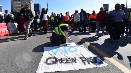 Port workers gather outside the entrance to protest against the implementation of the COVID-19 health pass, the Green Pass, in the workplace, in Genoa, Italy, October 15, 2021. © Reuters / Massimo Pinca