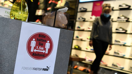 FILE PHOTO: A sign with Covid-19 distancing rules is seen at a retail shop in Berlin, Germany, April 25, 2020.