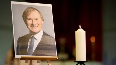 A candle and a portrait of British MP David Amess, who was stabbed to death during a meeting with constituents, are seen at the church of St Michael's and all Angels, in Leigh-on-Sea, Britain, October 17, 2021. © Reuters / Chris Radburn