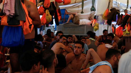 Migrants rest on the German NGO migrant rescue ship Sea-Watch 3 as the ship waits to be assigned a port of safety to disembark the 257 rescued migrants on board, off the coast of the island of Sicily, Italy, August 5, 2021. © Reuters / Darrin Zammit Lupi