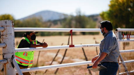 A security guard speaks with a compliance officer from the State of New Mexico at Bonanza Creek Ranch where on the film set of "Rust" in Santa Fe, New Mexico, U.S., October 22, 2021. © REUTERS/Adria Malcolm